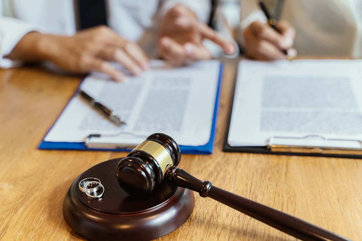 Legal gavel and wedding bands, representing divorce, highlighting Beth Reineke's expertise and innovative approach to divorce mediation.