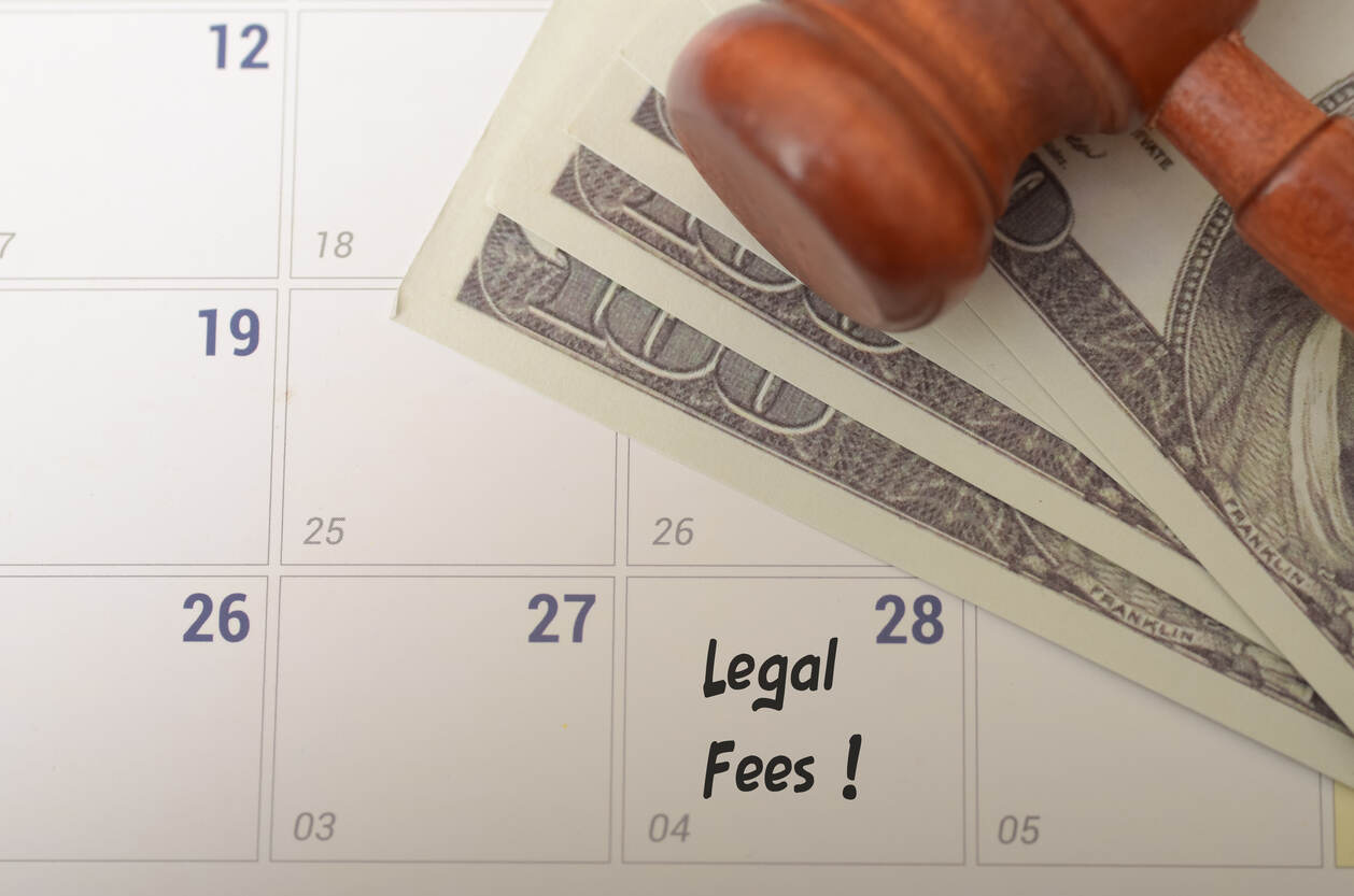 Calendar marked 'Legal Fees' with US dollar bills and a gavel, symbolizing the financial considerations of legal services when comparing mediation versus retainer fees.