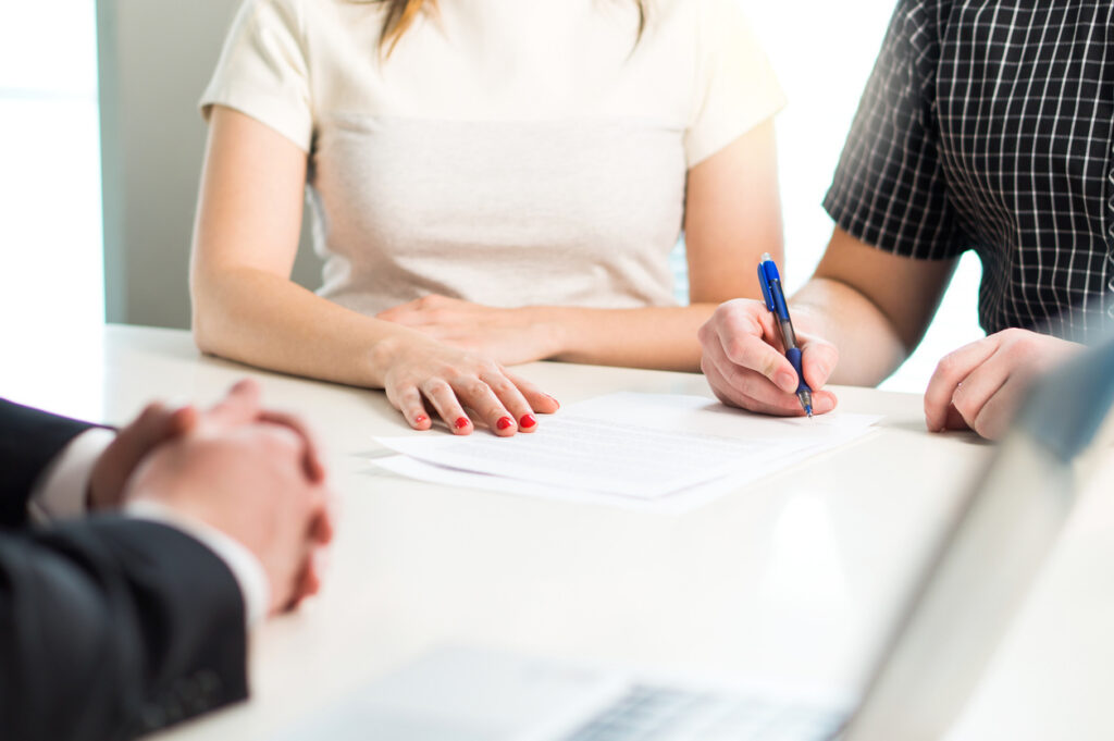 Young Couple Signing Marital Settlement Agreements